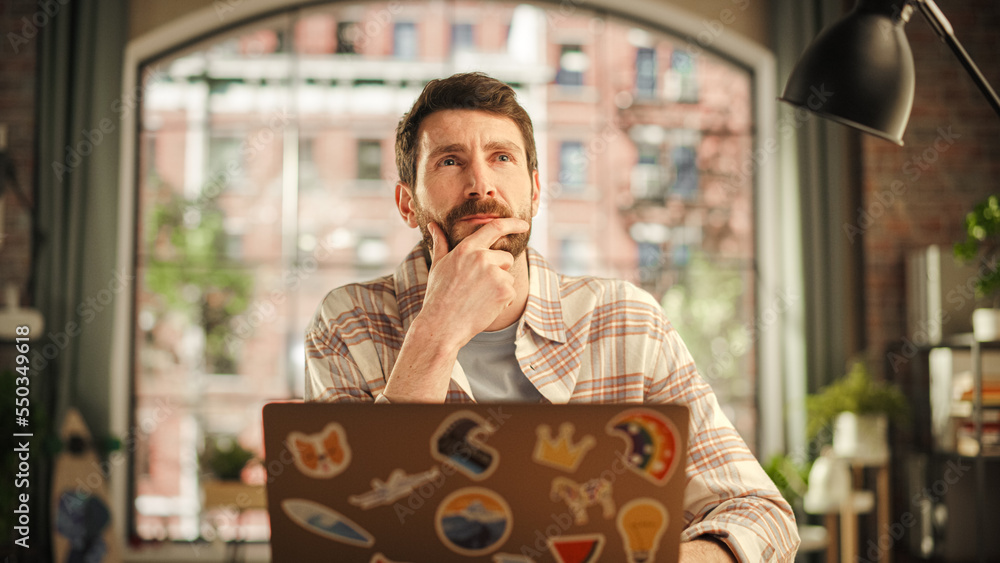 Professional Creative Man Sitting at a Desk at Home Office Studio, Working on Laptop Computer. Speci