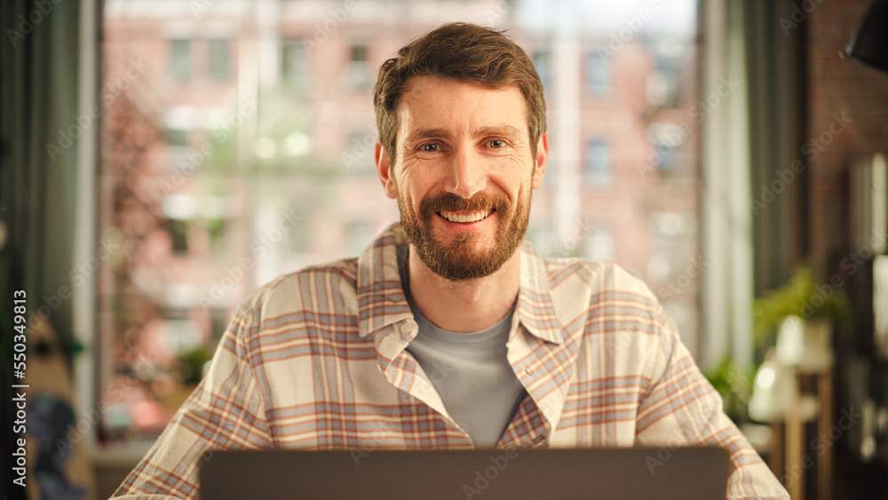 Portrait of a Happy Handsome Caucasian Man Working on Laptop Computer in Stylish Cozy Living Room. F