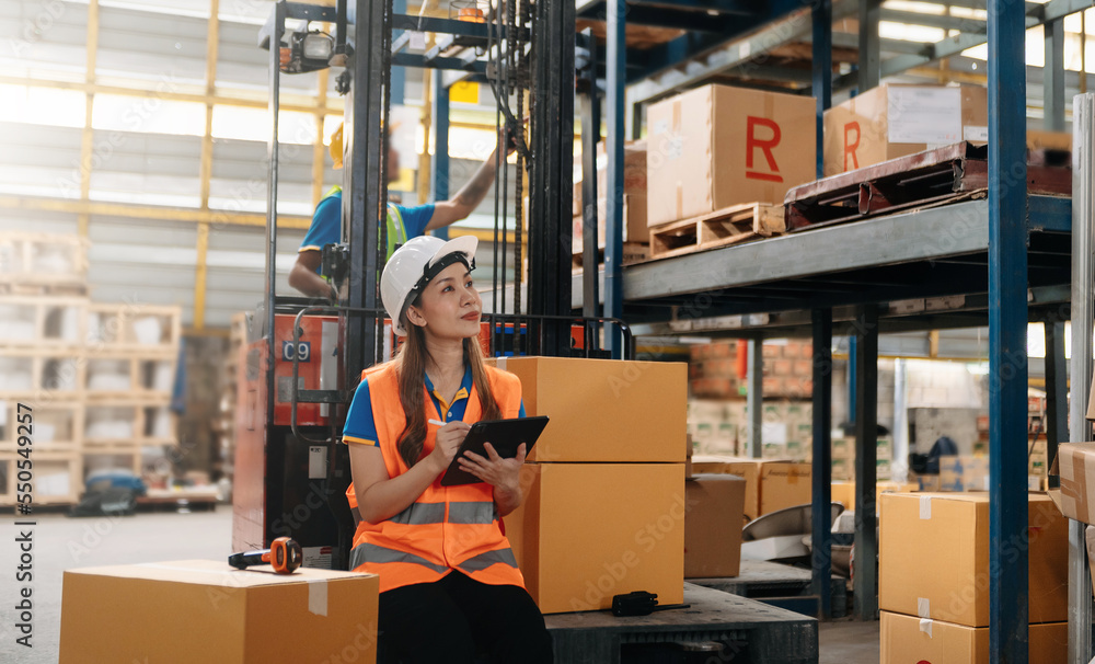 Management having discussion at warehouse with white hardhat using digital tablet Working in Logisti