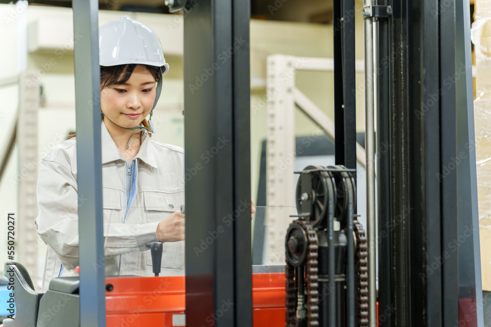 フォークリフトを運転する女性作業員