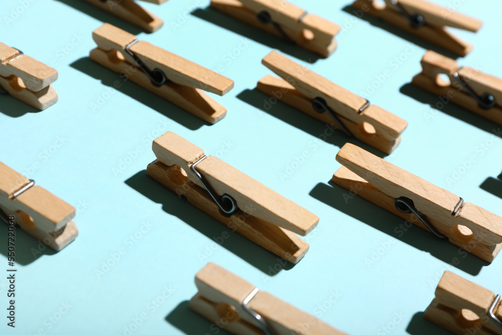 Wooden clothespins on blue background, closeup