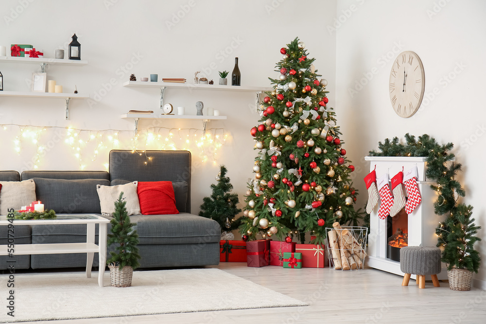 Interior of living room with sofa, Christmas trees and fireplace