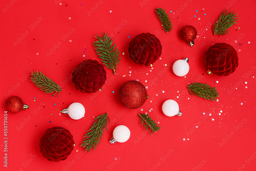 Christmas balls with fir branches and sequins on red background