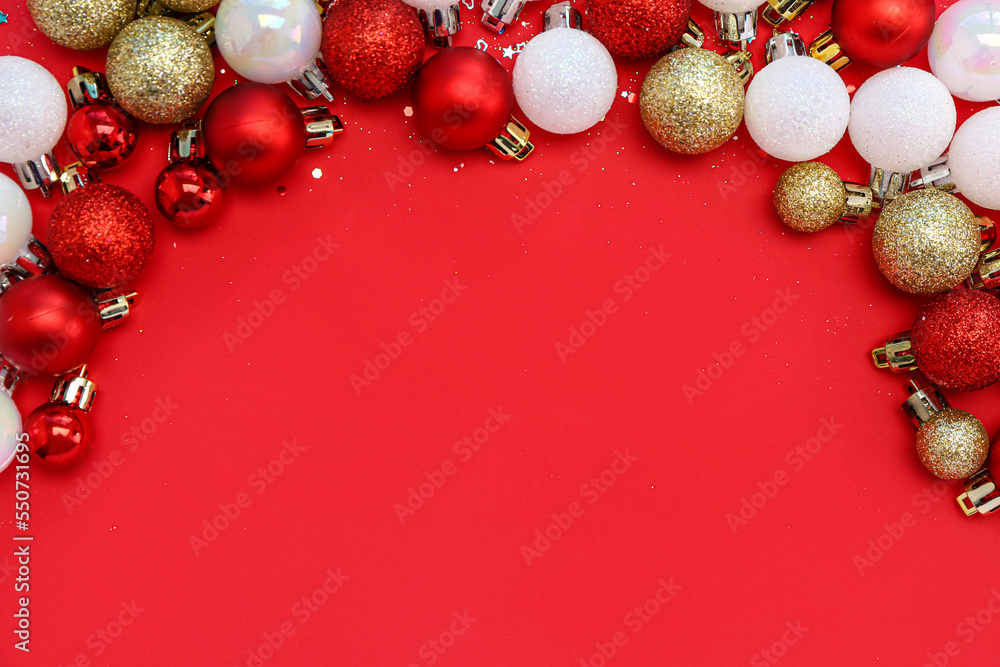 Frame made of beautiful Christmas balls on red background, top view