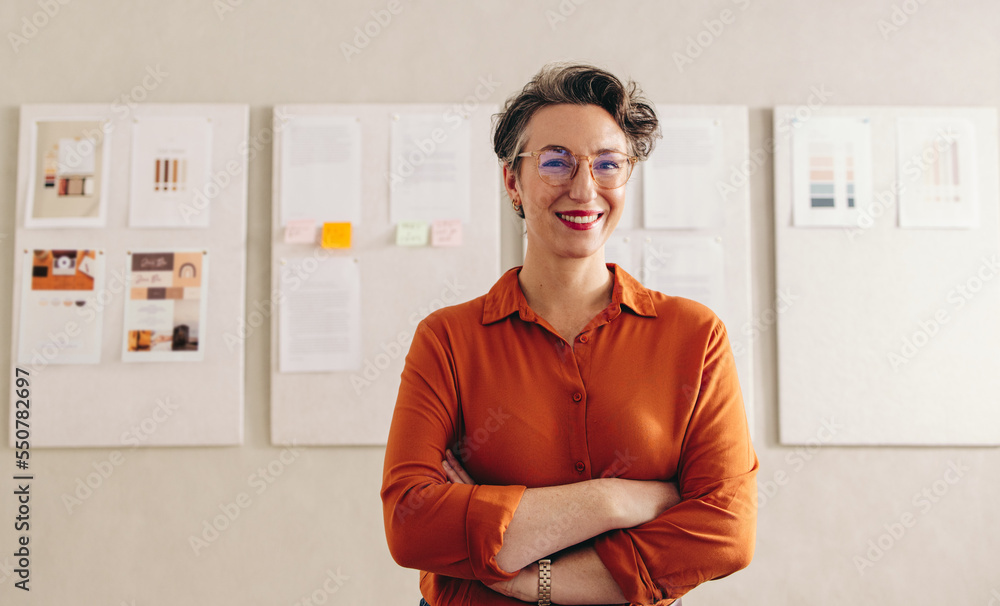 Happy designer smiling at the camera in her office