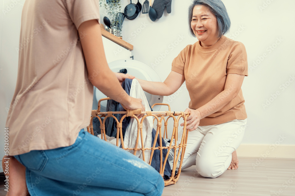 女儿和母亲在洗衣机附近一起完成家务