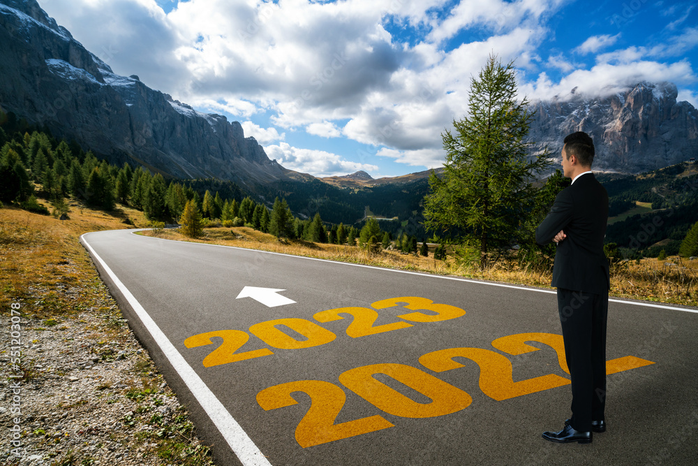 The 2023 New Year journey and future vision concept . Businessman traveling on highway road leading 