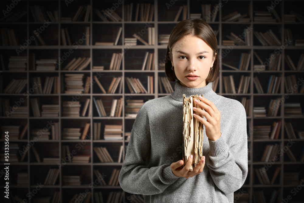 Pretty woman with old book in library