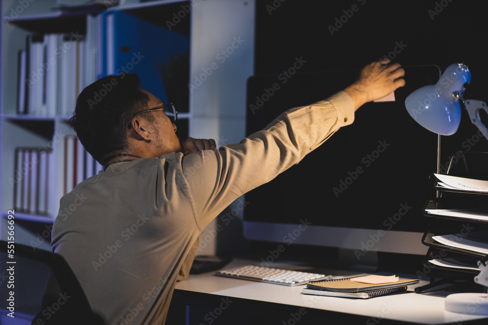 Responsible and determined businessman working overtime on computer in the night office.