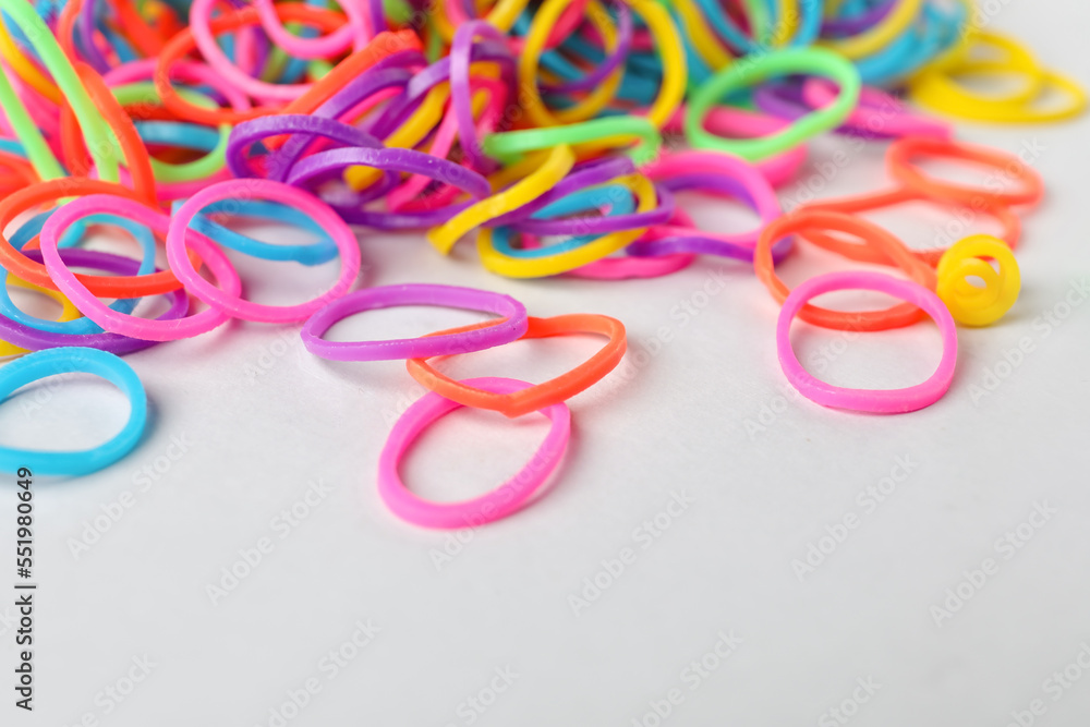 Colorful rubber bands on light background, closeup