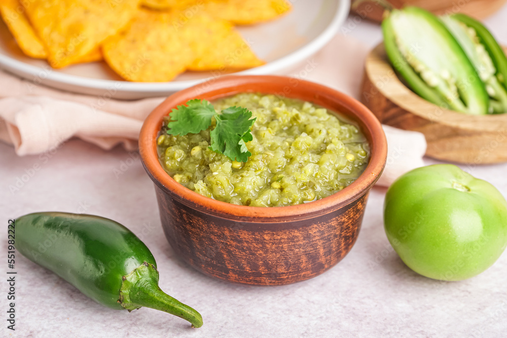 Bowl of tasty green salsa sauce on light table