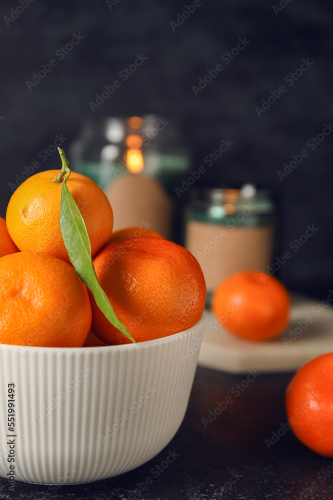 Bowl of fresh ripe tangerines on dark background, closeup