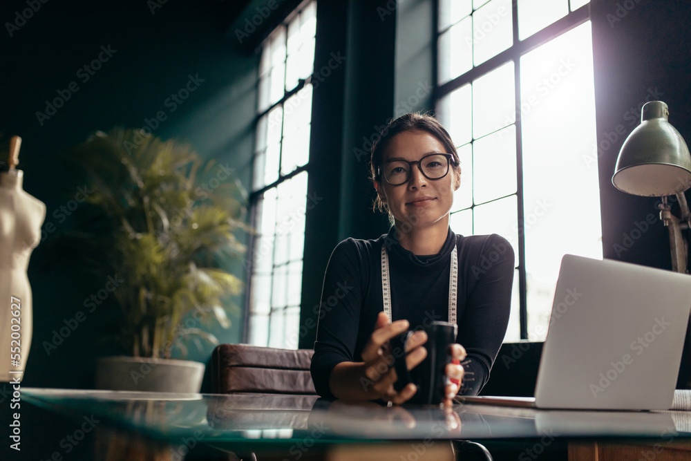 Female designer sitting at her desk with coffee