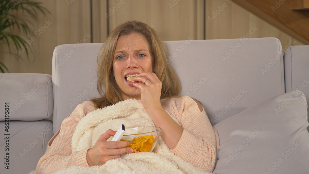 CLOSE UP: Young lady becoming upset while watching latest television news report