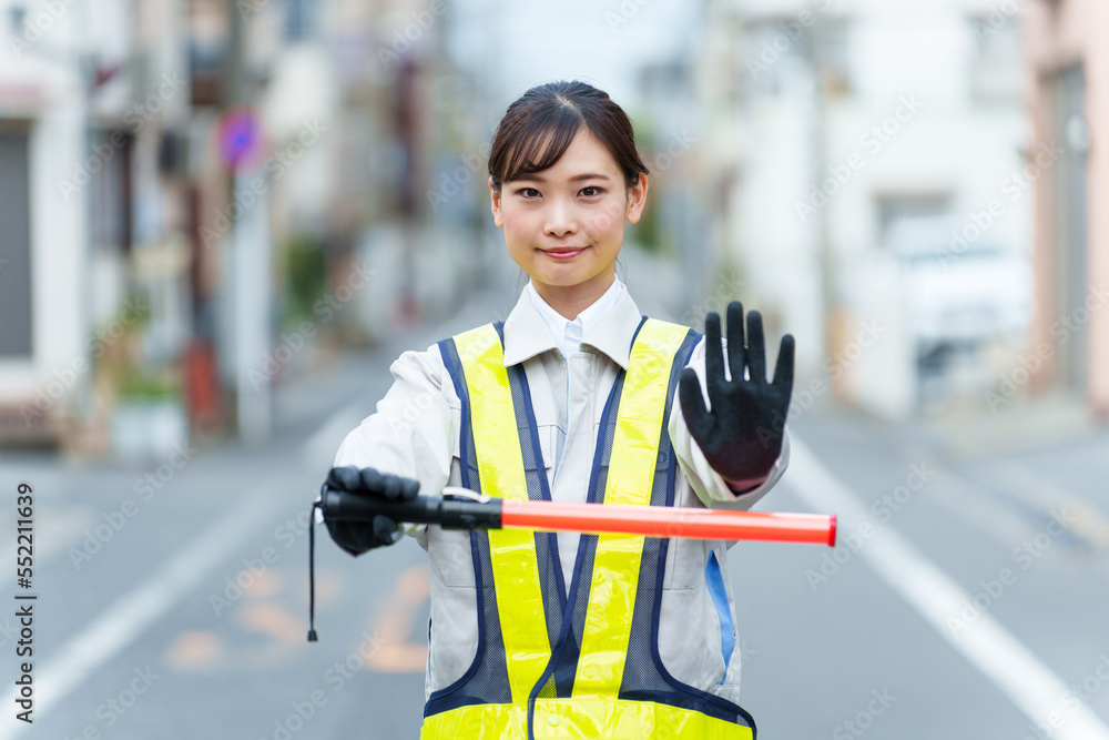 交通整理をする女性の警備員