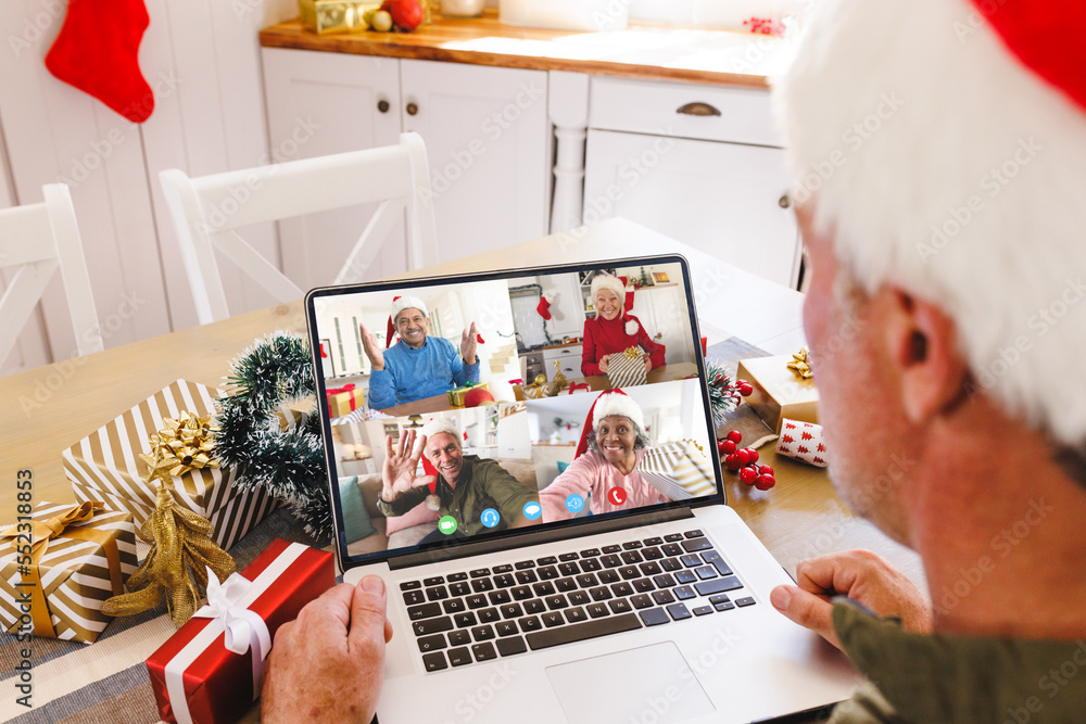 Senior caucasian man having christmas video call with diverse people