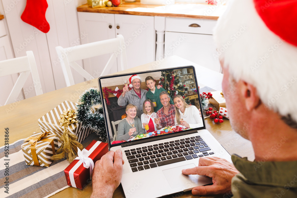 Senior caucasian man having christmas video call with caucasian family