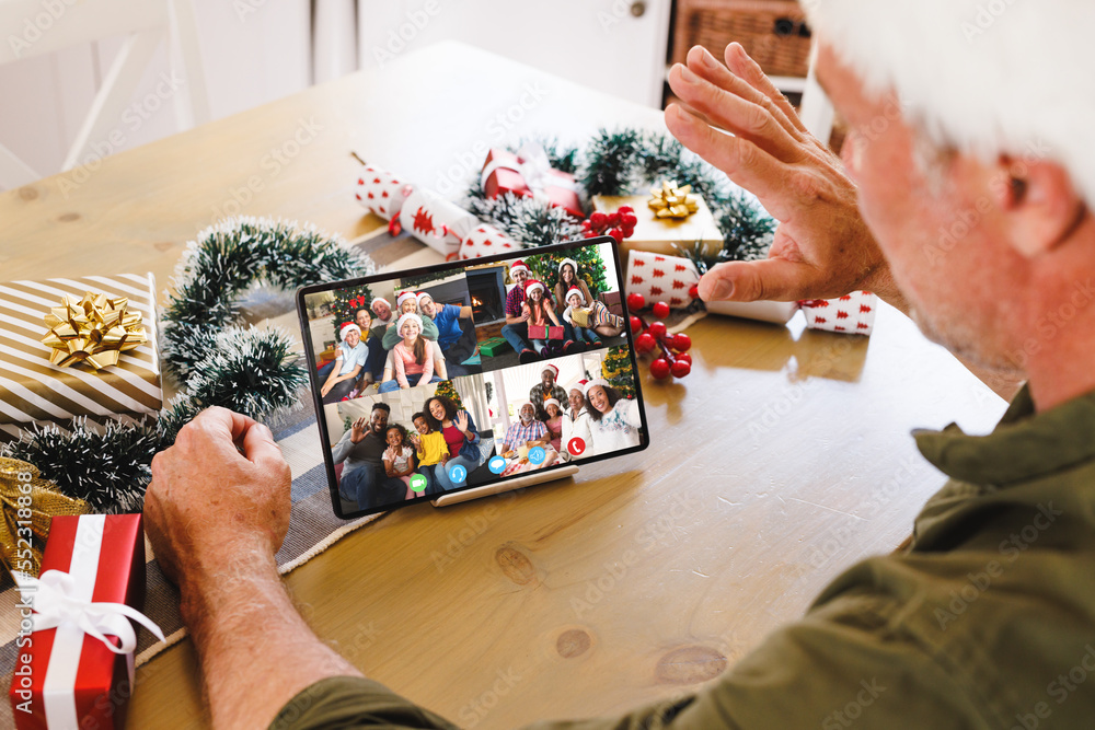 Senior caucasian man having christmas video call with diverse people