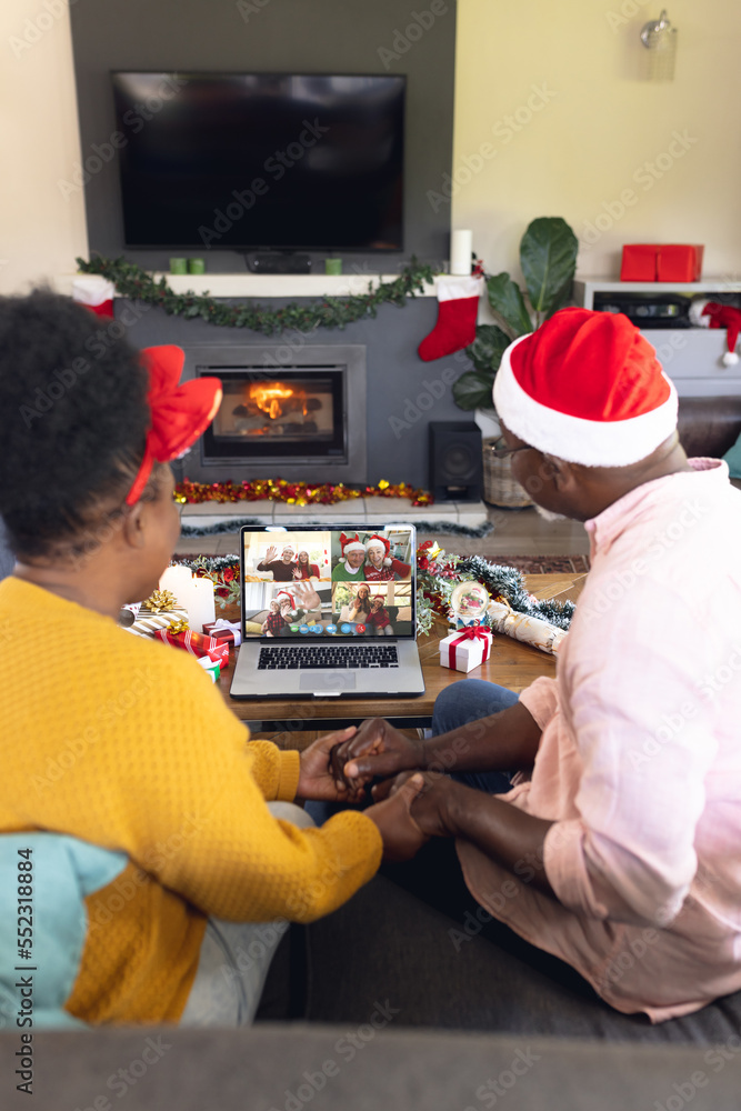 Senior african american couple having christmas video call with diverse people