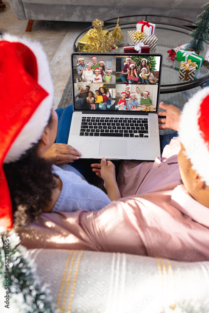 African american couple having christmas video call with diverse people