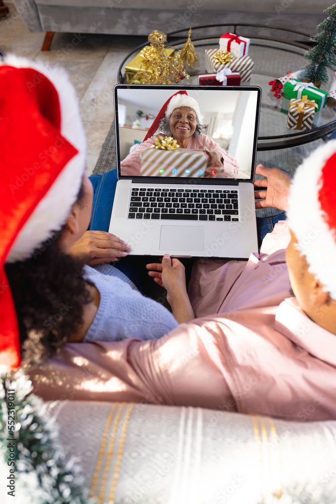 African american couple having christmas video call with senior african american woman