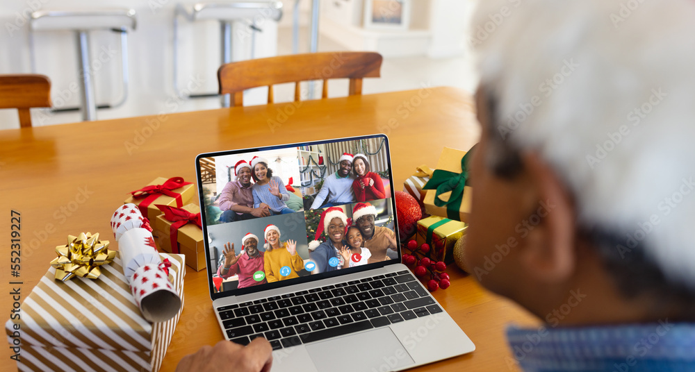 Biracial man with santa hat having video call with happy diverse friends