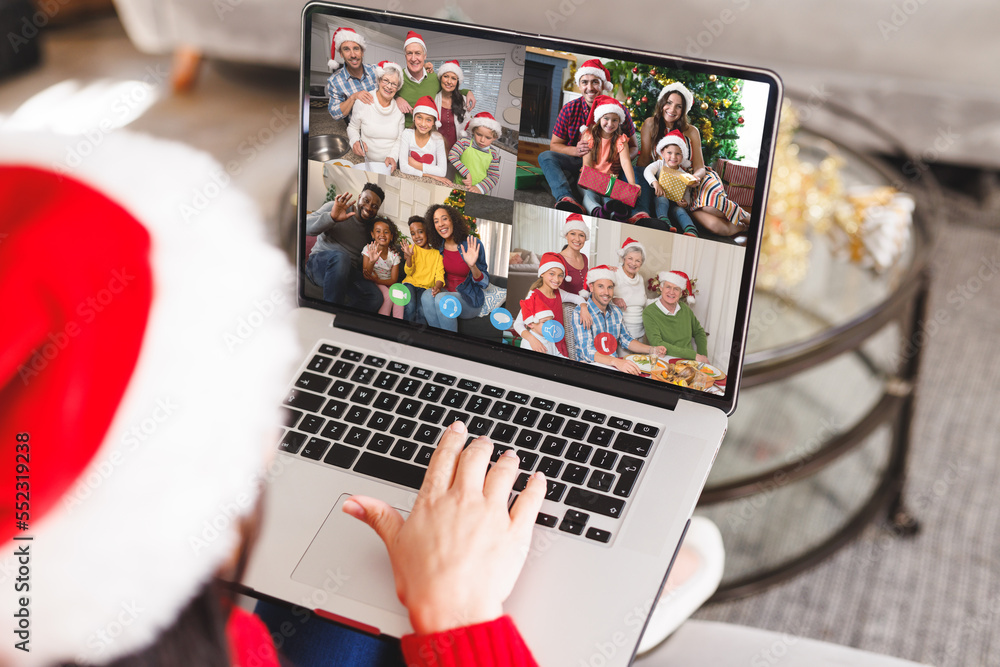 Caucasian woman with santa hat having video call with happy diverse friends