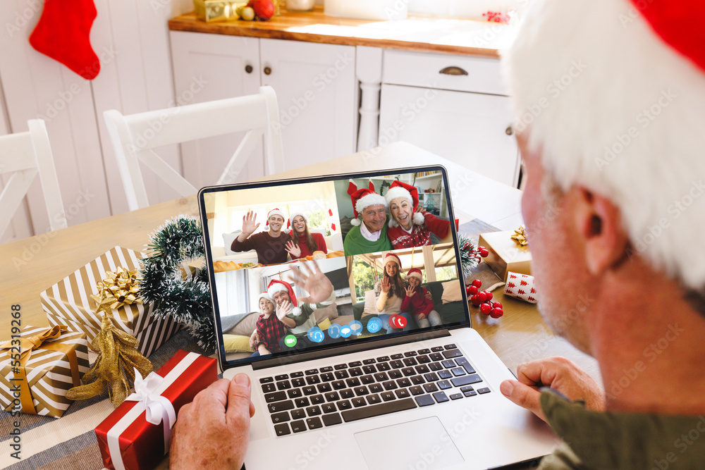 Caucasian man with santa hat having video call with happy caucasian friends