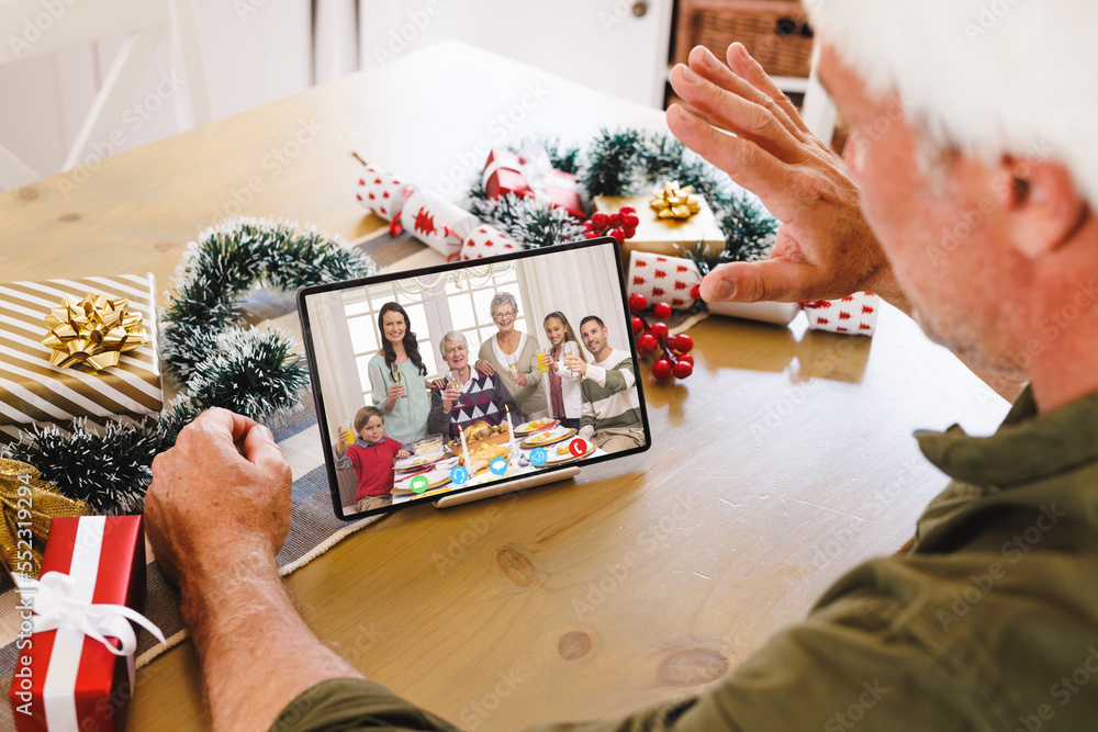 Caucasian man with santa hat having video call with happy caucasian family