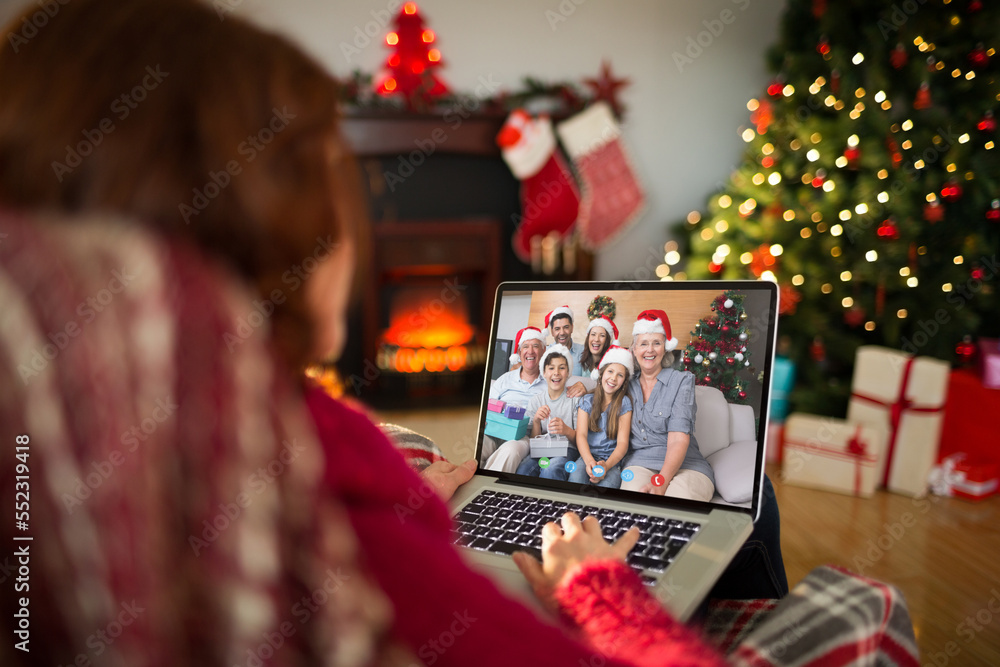 Caucasian woman with christmas decorations having video call with happy caucasian family