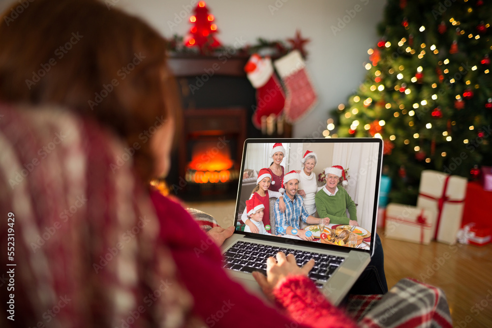 Caucasian woman with christmas decorations having video call with happy caucasian family