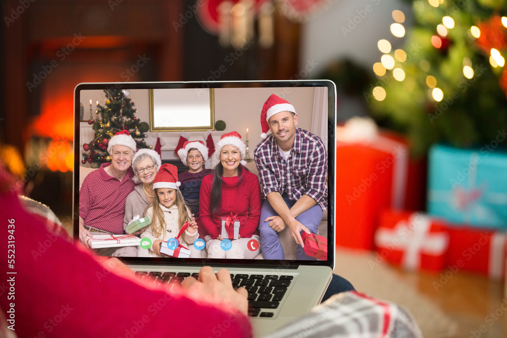 Caucasian woman with christmas decorations having video call with happy caucasian family