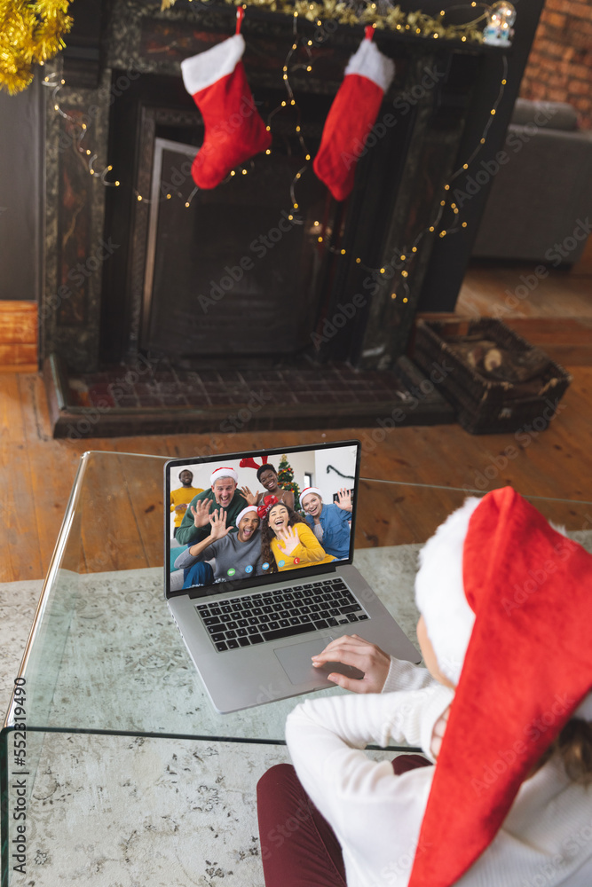 Caucasian woman with santa hat having video call with happy diverse friends