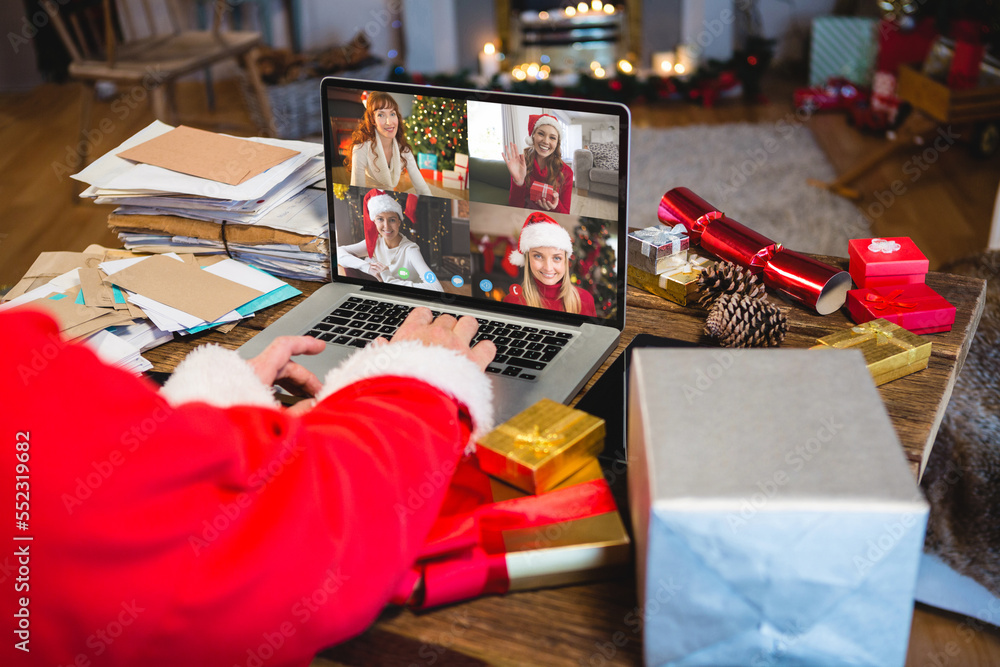 Santa claus having video call with happy caucasian friends