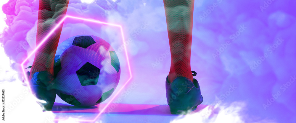 Low section of male player wearing red socks and black shoes with ball and illuminated hexagon