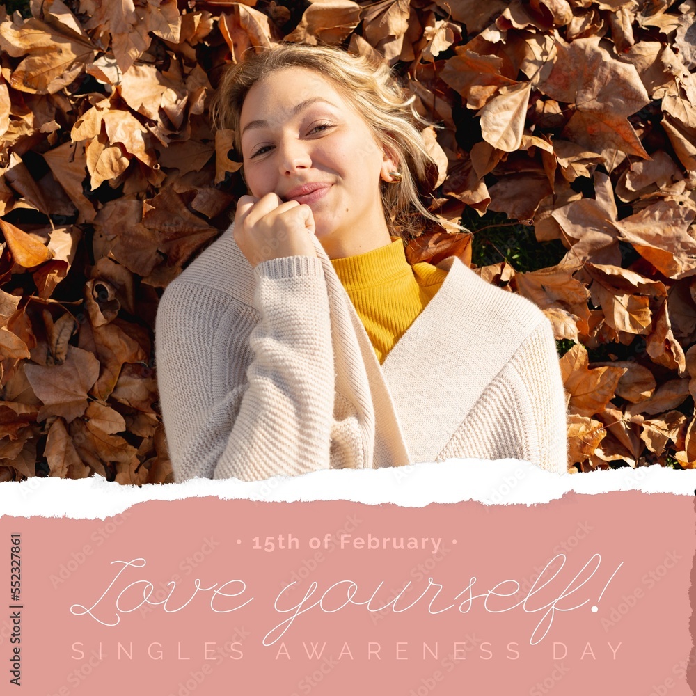 Composition of singles awareness day text and smiling caucasian woman lying on leafy background