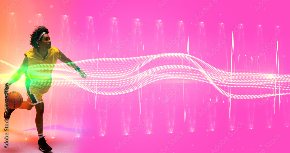 Biracial player dribbling basketball over illuminated wave and zig zag pattern on pink background