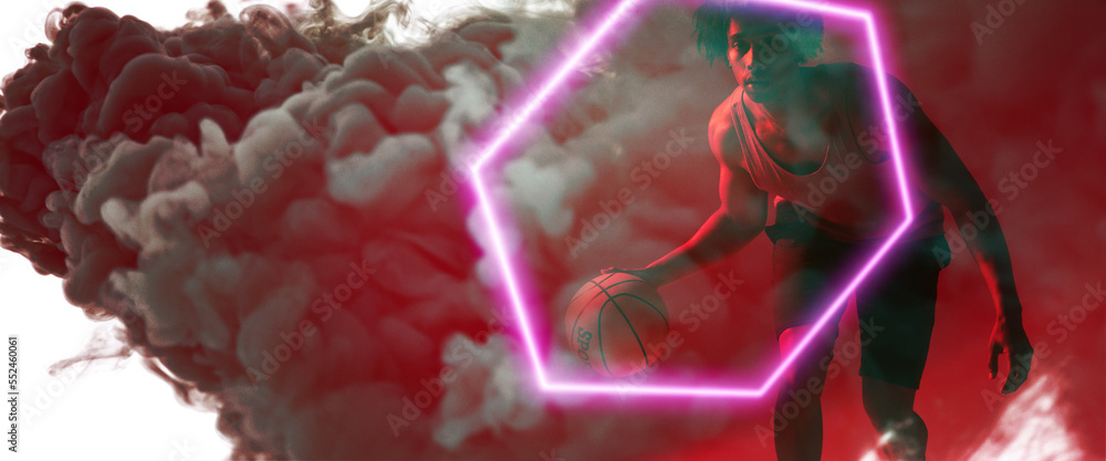 Composite of biracial basketball player playing with ball by hexagon over smoky background