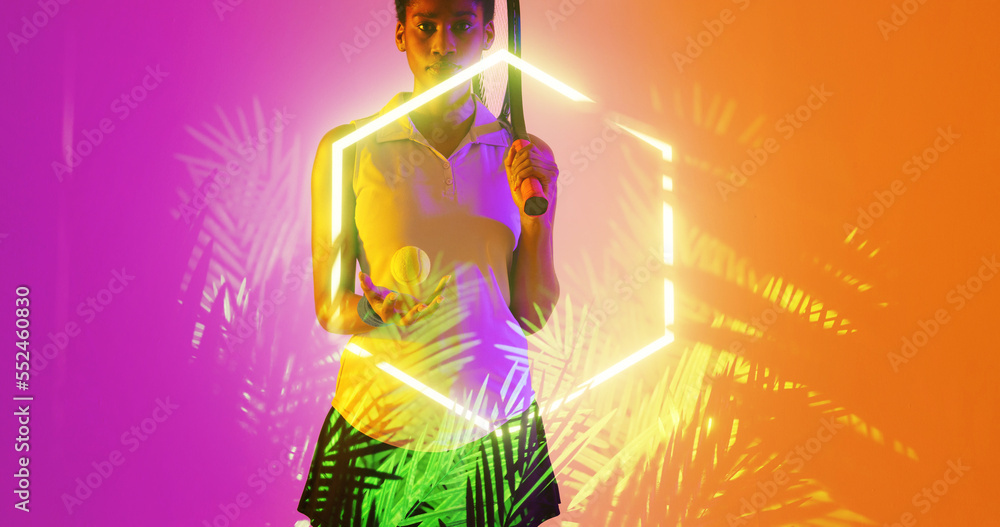 Biracial female player with tennis racket and ball standing by illuminated hexagon and plants