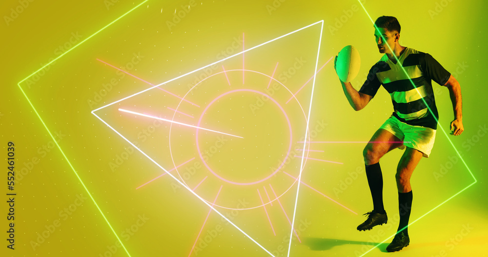 Caucasian male player playing with rugby ball over illuminated geometric shapes on yellow background