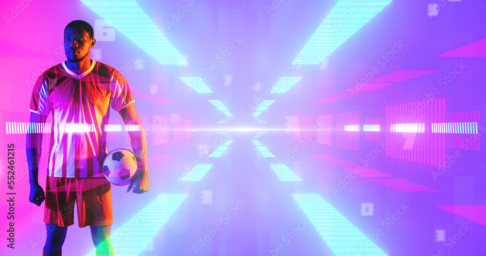 African american male player with soccer ball standing over illuminated abstract pattern