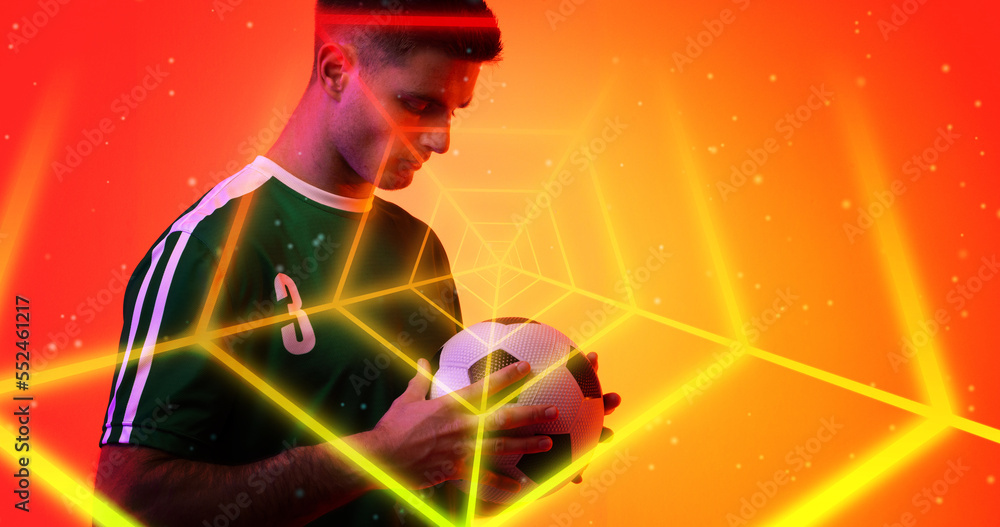 Digital composite of young caucasian player holding soccer ball seen through with neon spider web