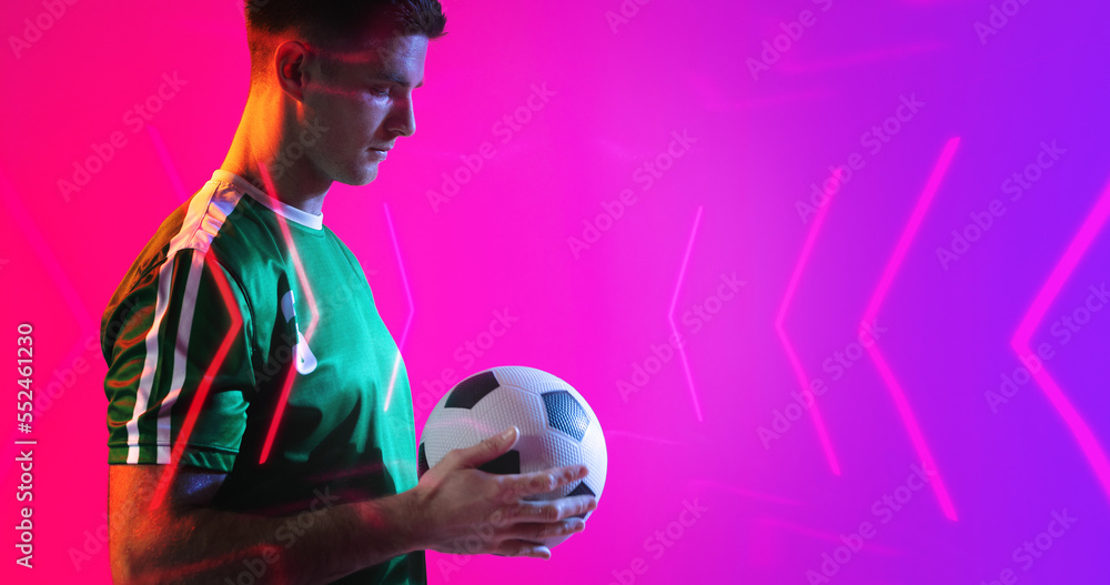 Composite of young caucasian player holding soccer ball with abstract neon pattern, copy space