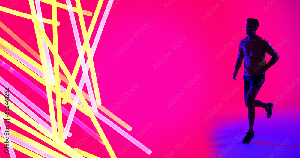 Caucasian young sportsman with colorful neon design running over pink background, copy space