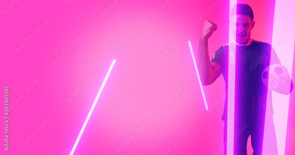 Composite of caucasian soccer player celebrating success with neon over pink background, copy space