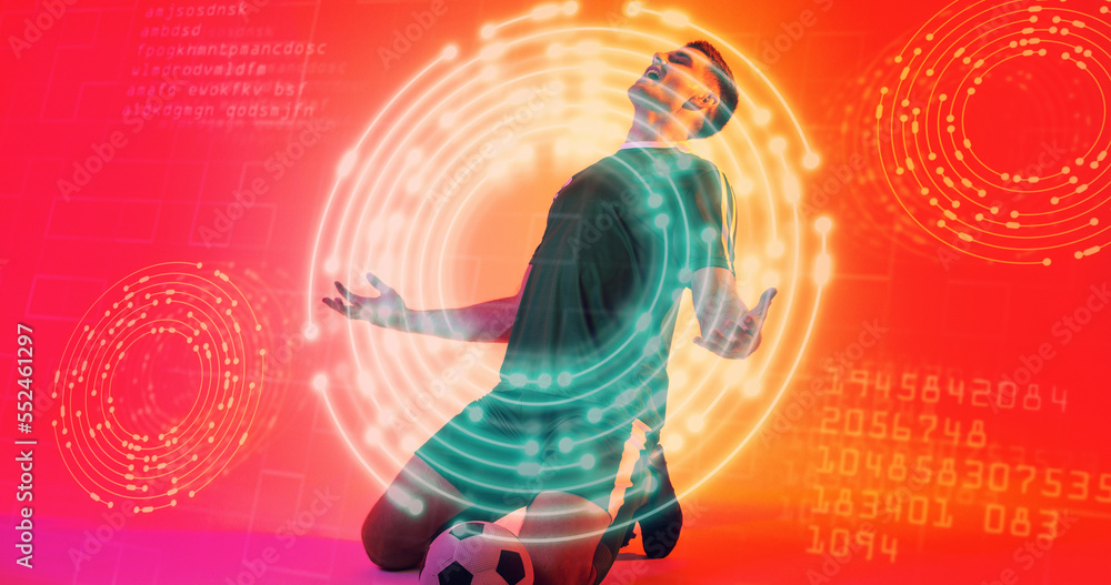 Caucasian young soccer player kneeling over neon design with computer codes in background