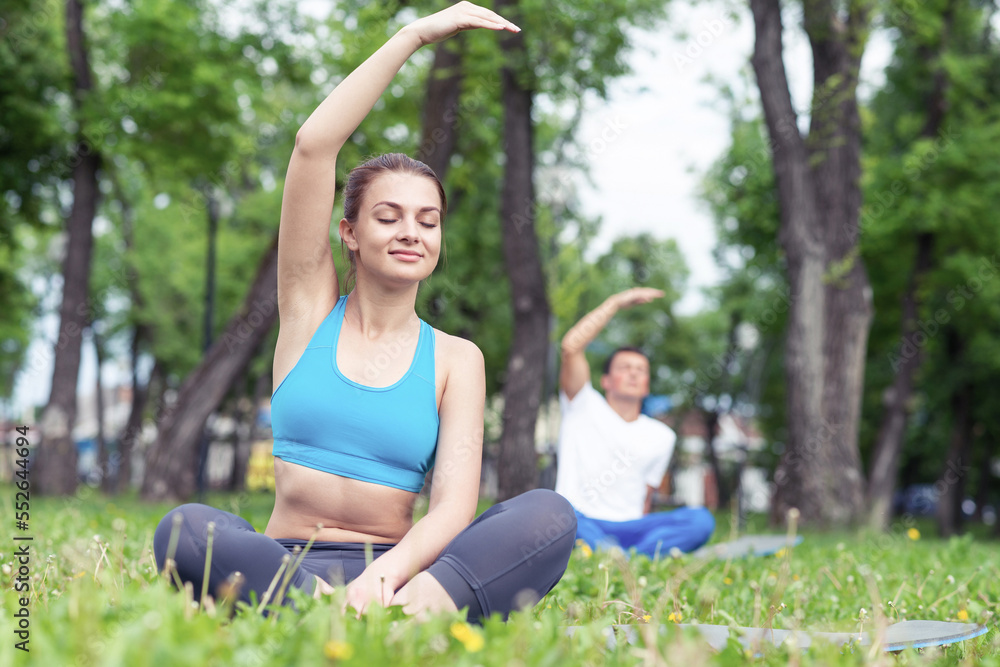 Couple of young sporty people practicing yoga