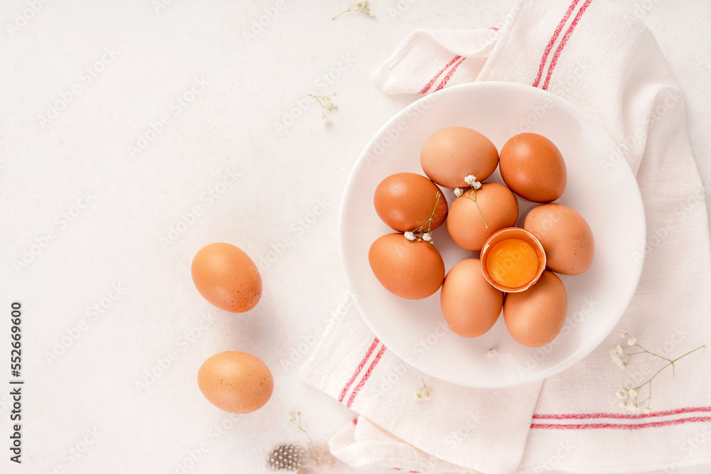 Egg on white texture with white napkin. Top view of raw brown eggs on white plate .