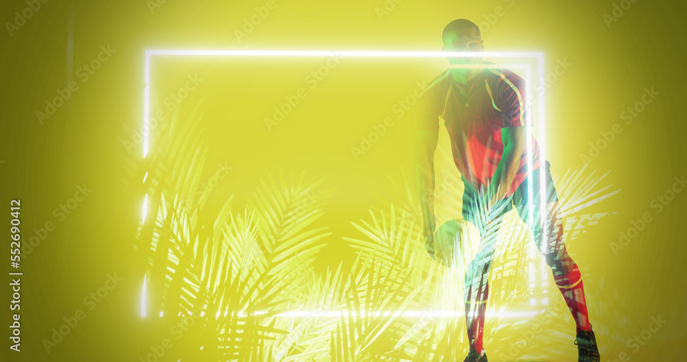 African american rugby player standing by illuminated plants and rectangle on yellow background