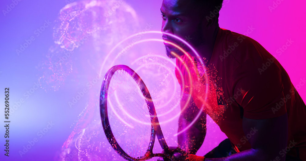 African american male player holding racket and standing by illuminated circles